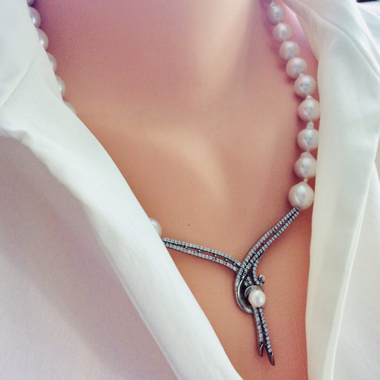 Side close-up of baroque pearl necklace worn by mannequin, elegant bridal jewelry.