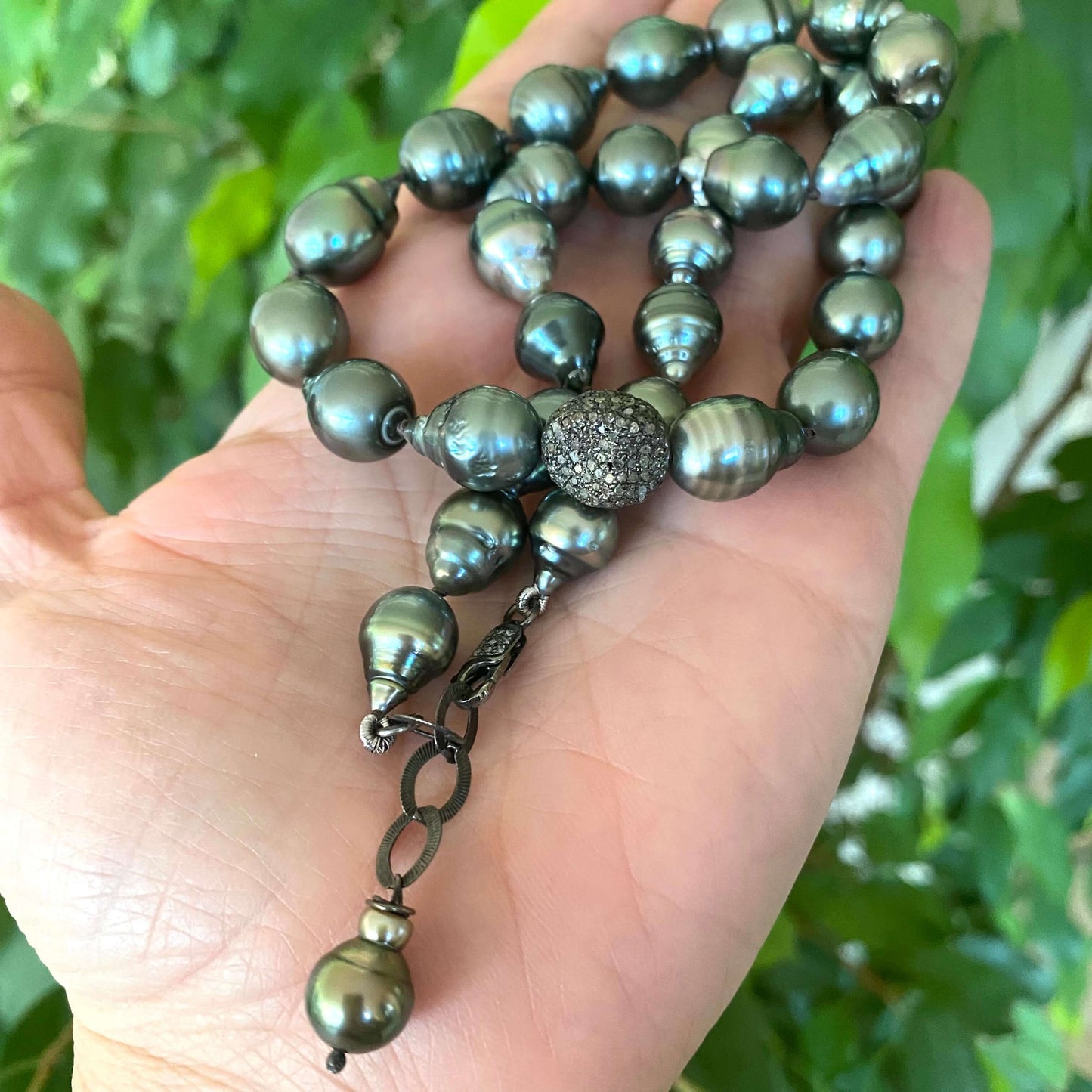 Tahitian baroque pearl necklace with champagne diamonds showcasing the unique pearls and elegant design in a hand display.