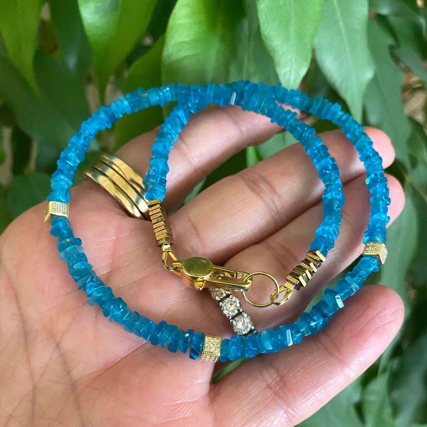 Blue Apatite Choker Necklace with Faceted Beads shown in hand, showcasing its vibrant ocean-blue color and elegant design.