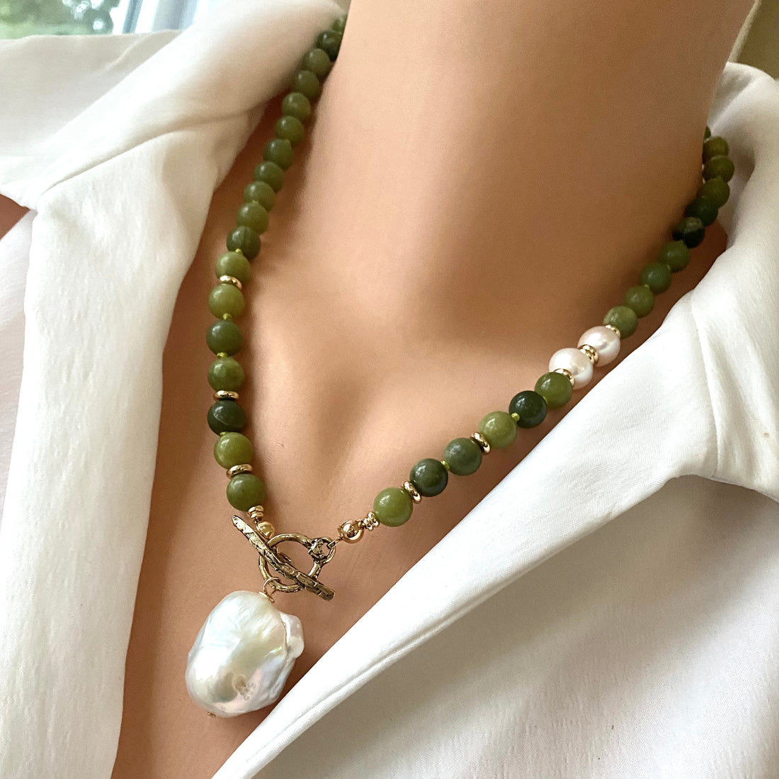 handcrafted jade and pearl necklace with green jade beads, freshwater pearls, and baroque pearl pendant worn on white blouse