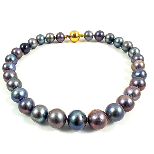 A strand of iridescent freshwater pearls with a metallic gold clasp, displayed on a clean white background.