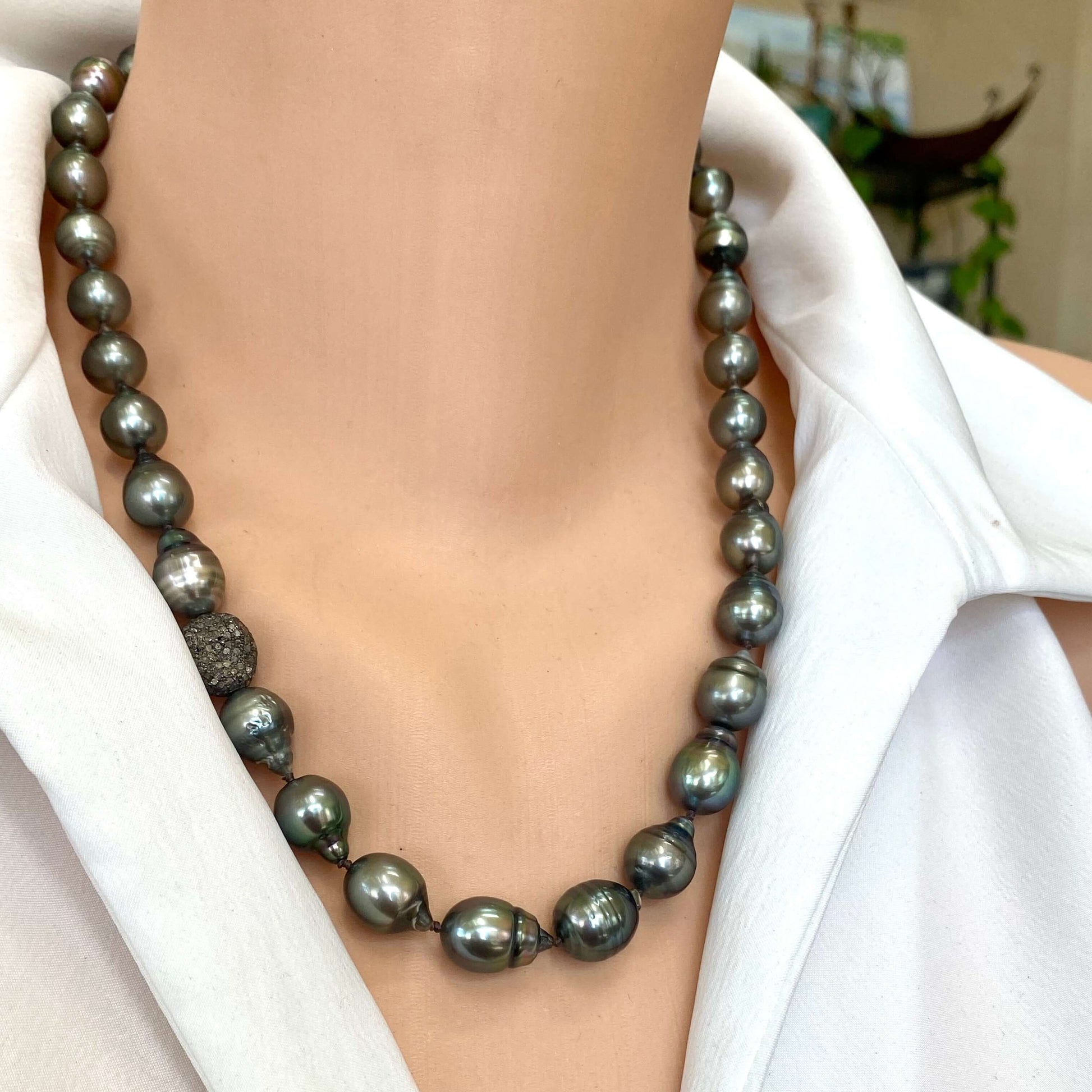 Tahitian baroque pearl necklace with champagne diamonds showcased on a mannequin against a white background.