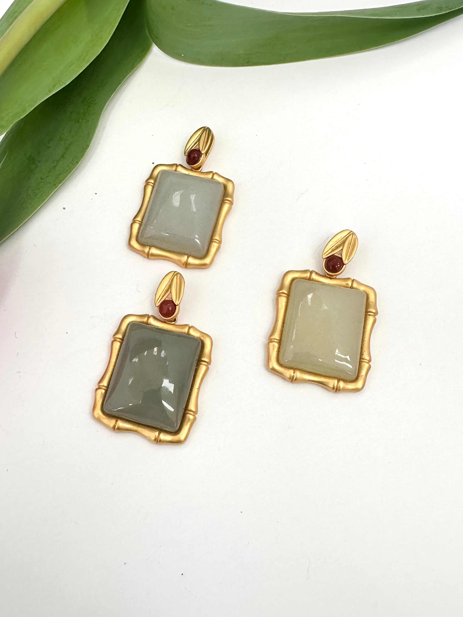Bamboo-style jade pendants in gold vermeil with red agate accents, three green tones