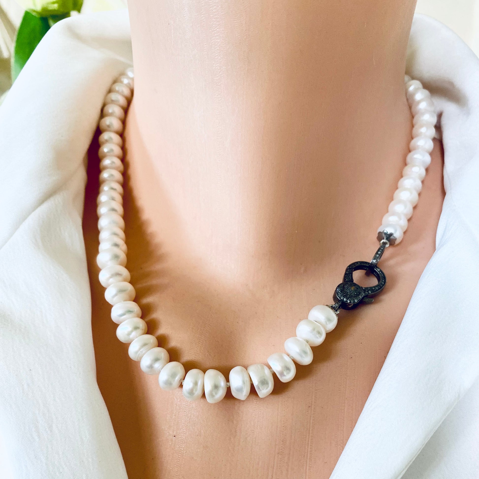 Button pearl necklace with diamond pavé featuring hand-knotted pearls and decorative clasp detail