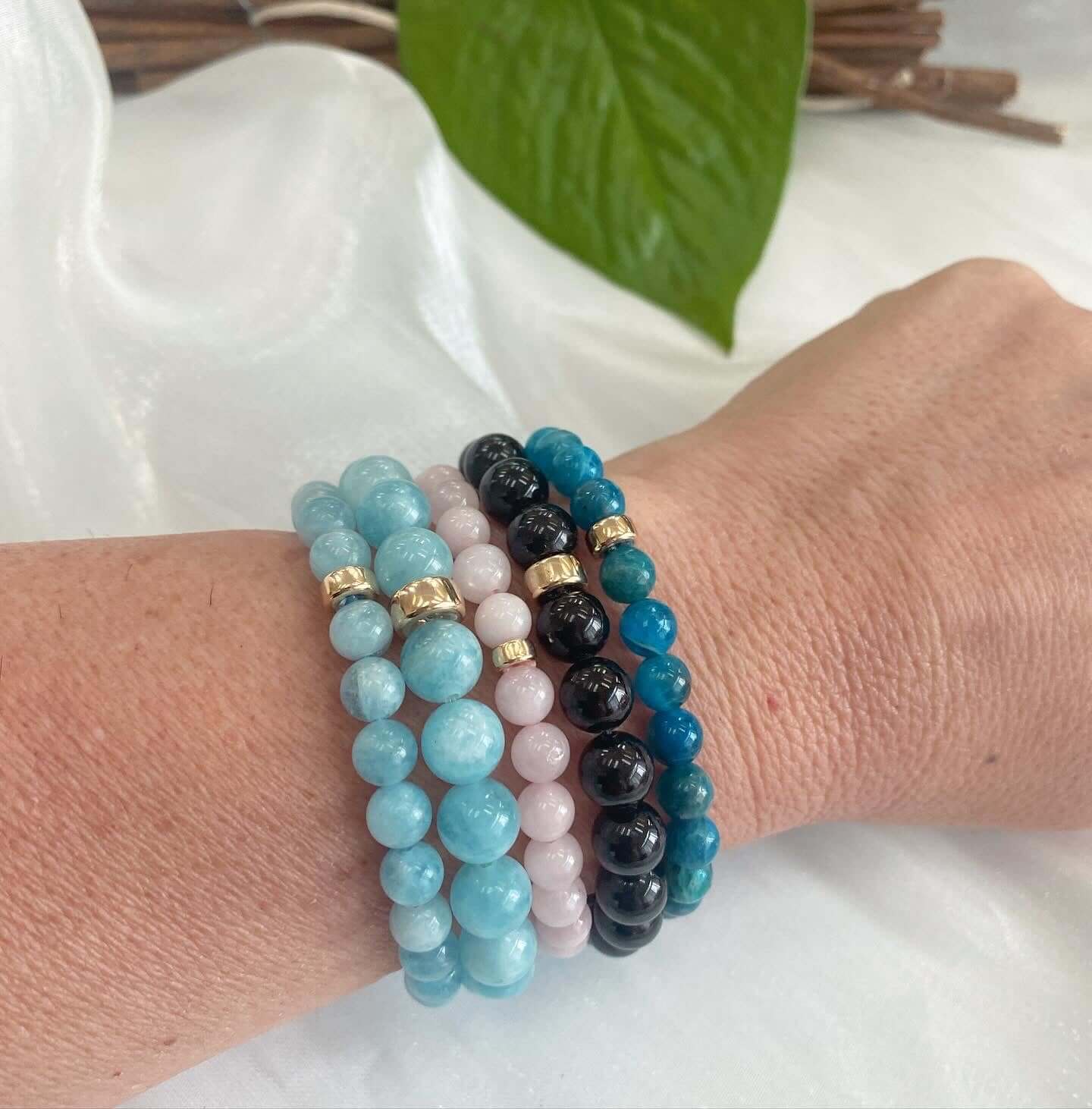 Rose quartz stretch bracelet with 6mm beads showcased on a wrist, featuring various colors and 14K gold filled accents.