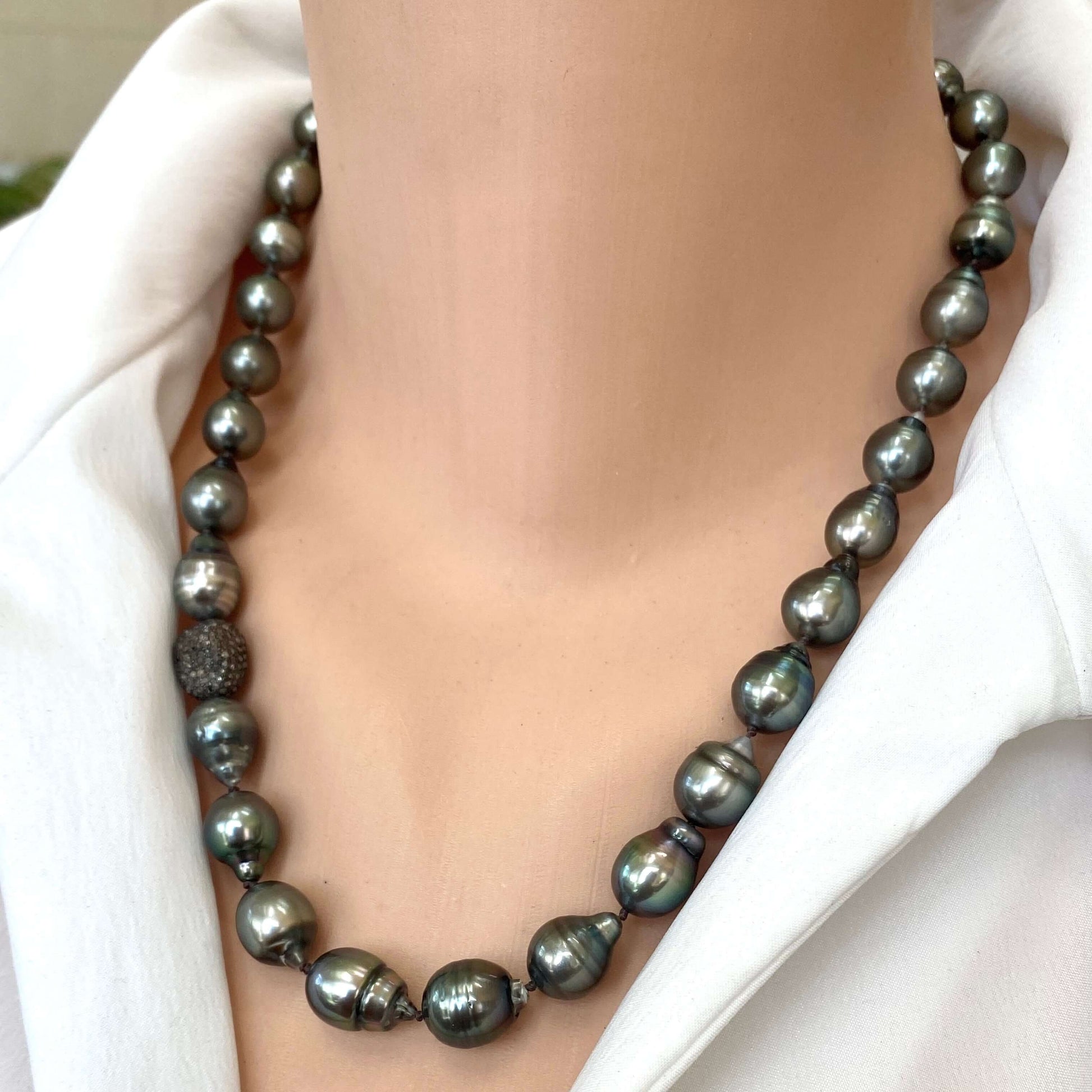 Tahitian baroque pearl necklace with champagne diamonds worn on a model's neck, showcasing its elegant design.
