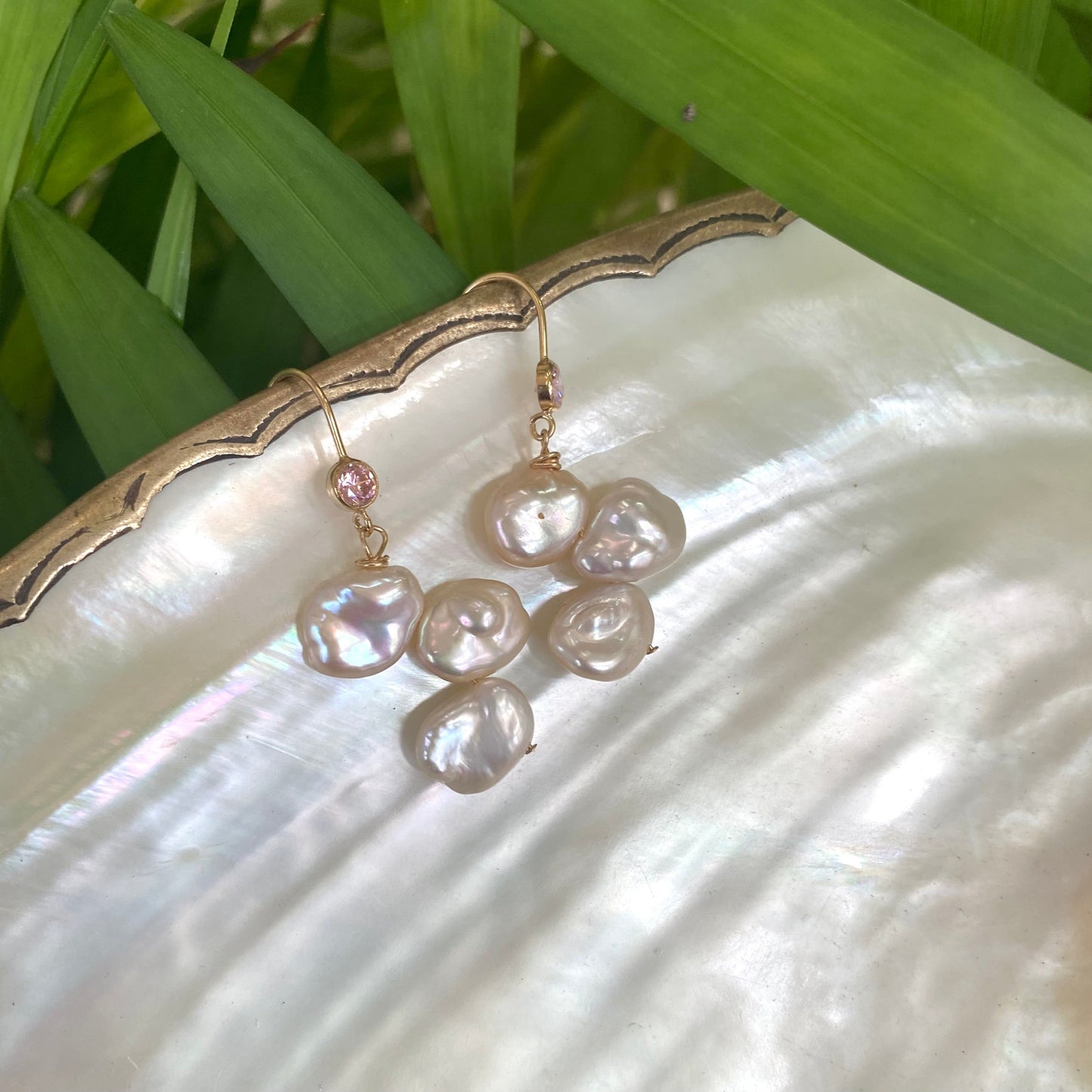 Elegant earrings composed of Natural Keshi pink and white pearls hanging from gold filled hooks with pink cubic zirconia bezel
