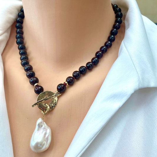 Garnet pearl necklace worn at the neckline with baroque pearl pendant and gold toggle clasp