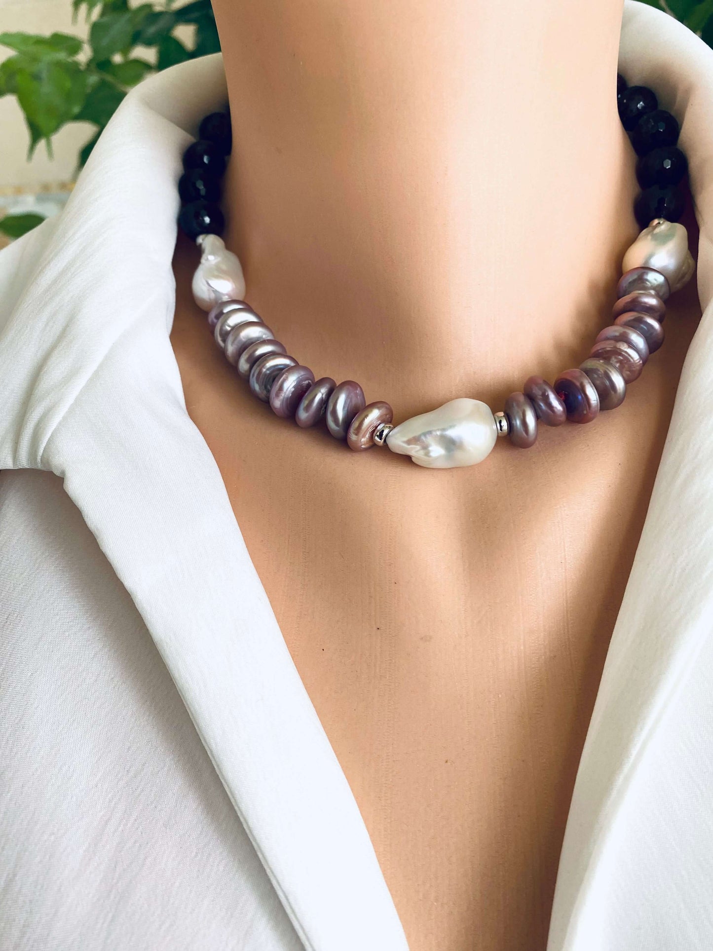 Garnet pearl necklace featuring Baroque and Coin pearls, elegantly displayed on a mannequin against a stylish backdrop.