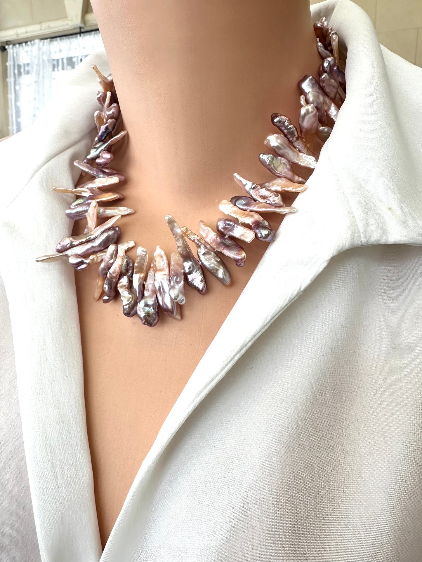 Handcrafted Biwa Pearl Necklace featuring iridescent purplish long stick pearls on mannequin side view.