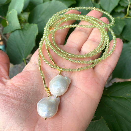 Peridot baroque pearl lariat necklace held in hand highlighting faceted peridot beads and white pearls