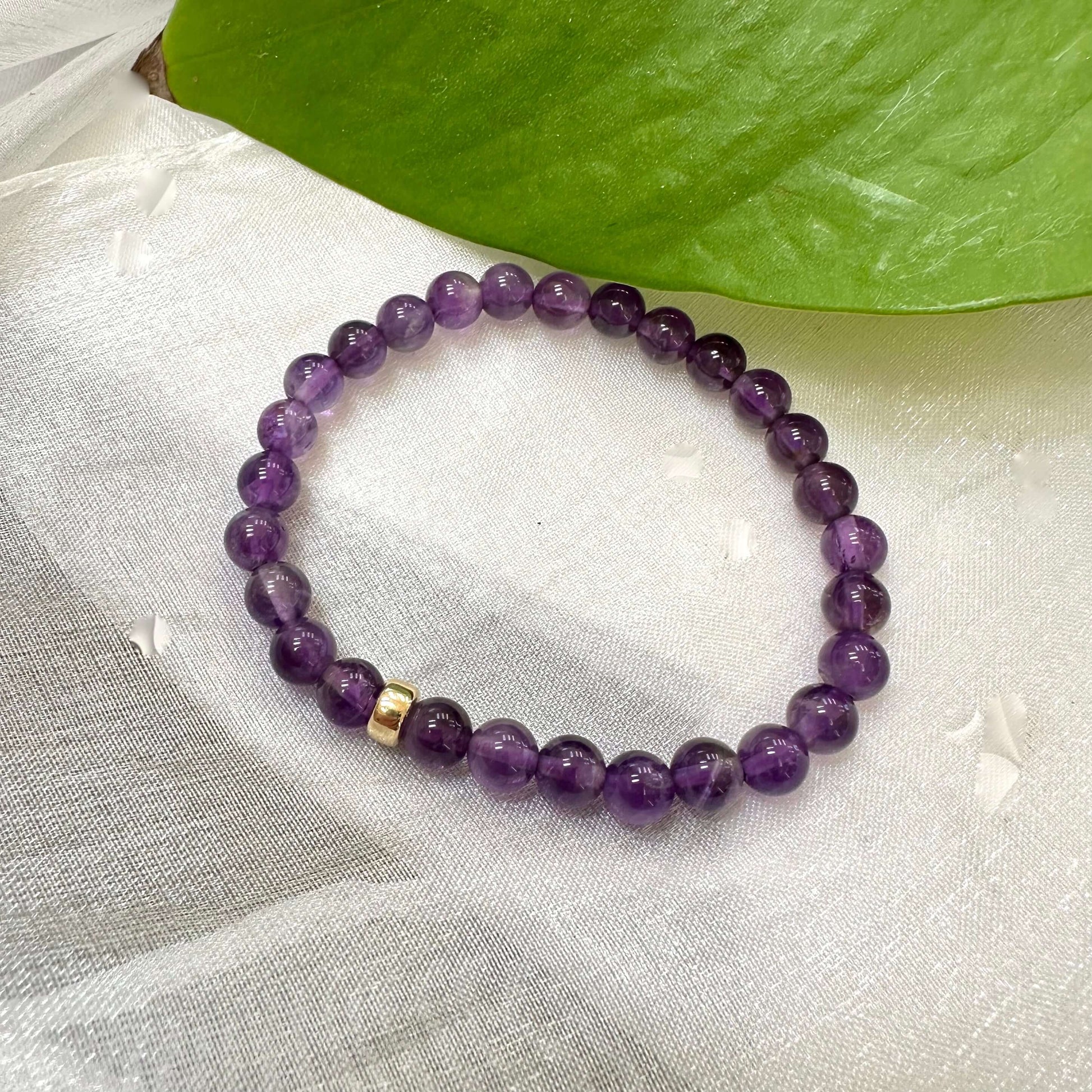 Amethyst Bracelet displayed on white cloth – gemstone bead close-up