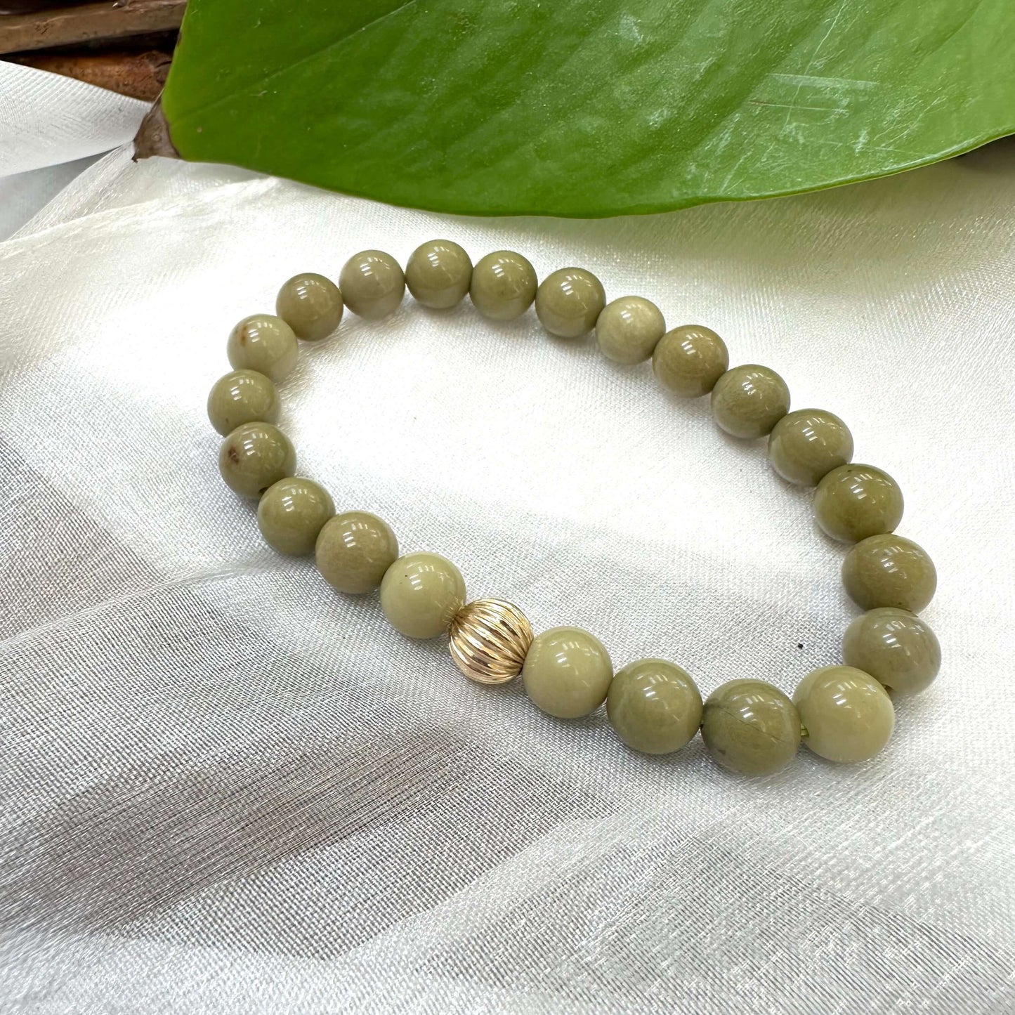 Green Olivine Jasper Bracelet displayed on white cloth – detailed close-up