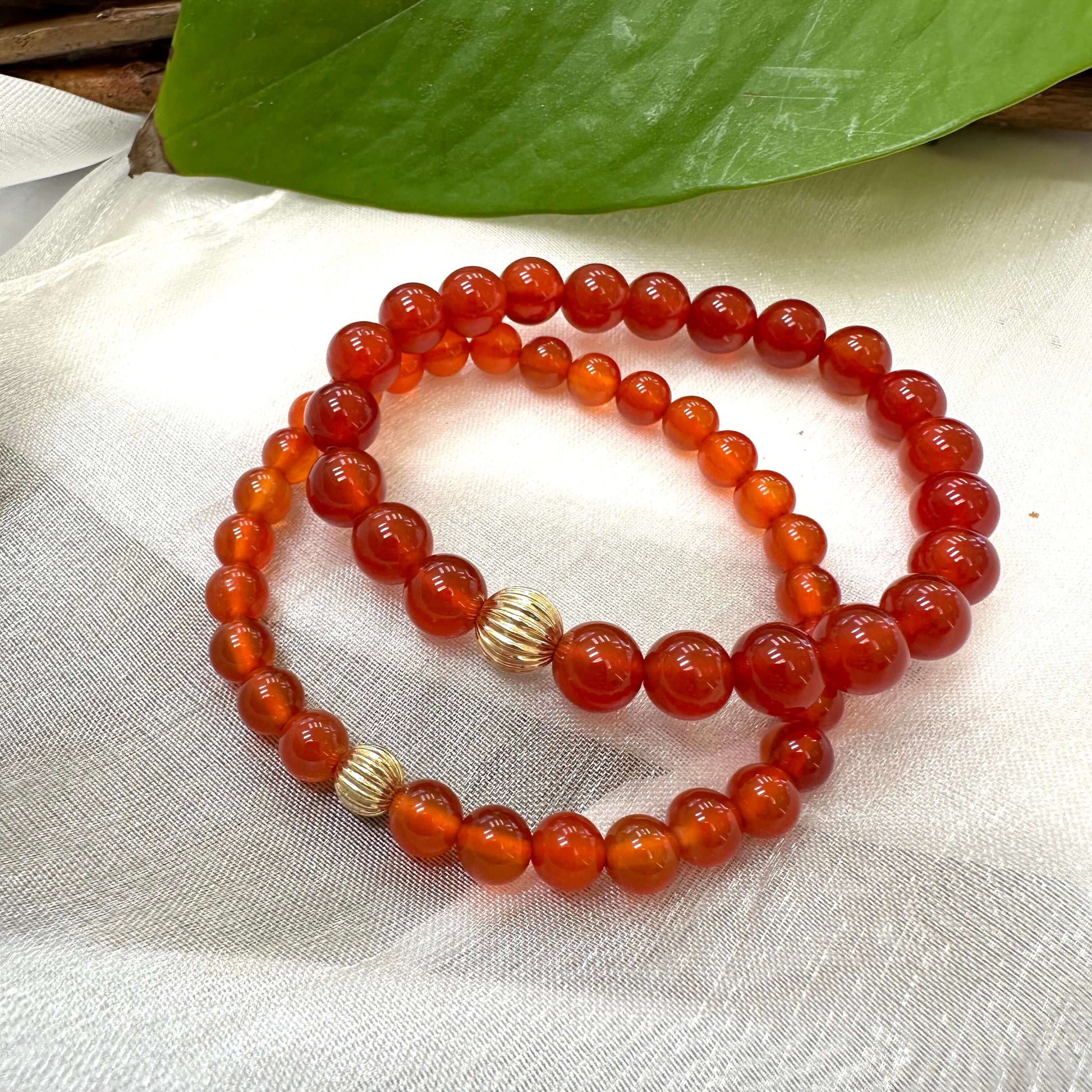 Orange Carnelian Bracelet stacked pair on white cloth – two-bracelet close-up
