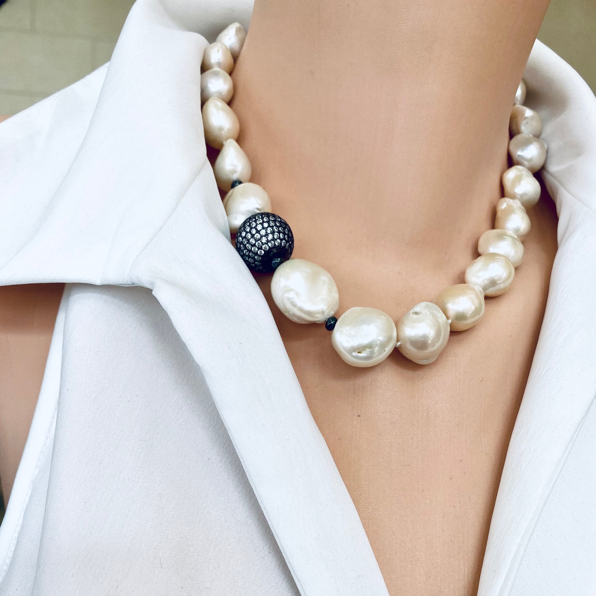 Ivory baroque pearl bridal necklace worn on model featuring large ivory pearls and black rhodium clasp