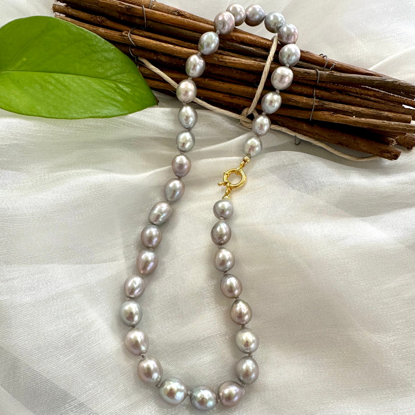 Grey Pearl Necklace displayed on white cloth – product detail close-up