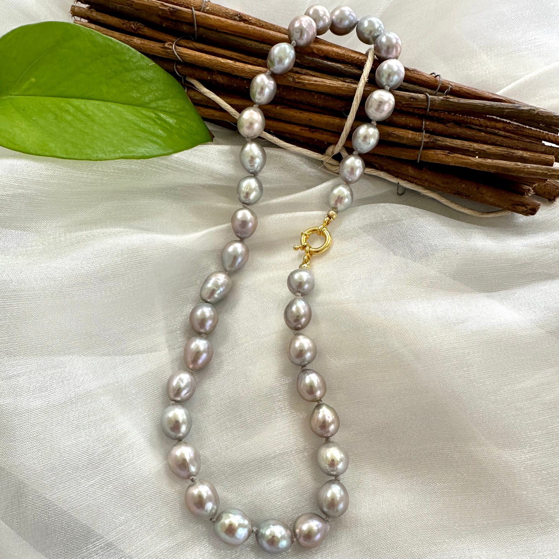 Grey Pearl Necklace displayed on white cloth – product detail close-up