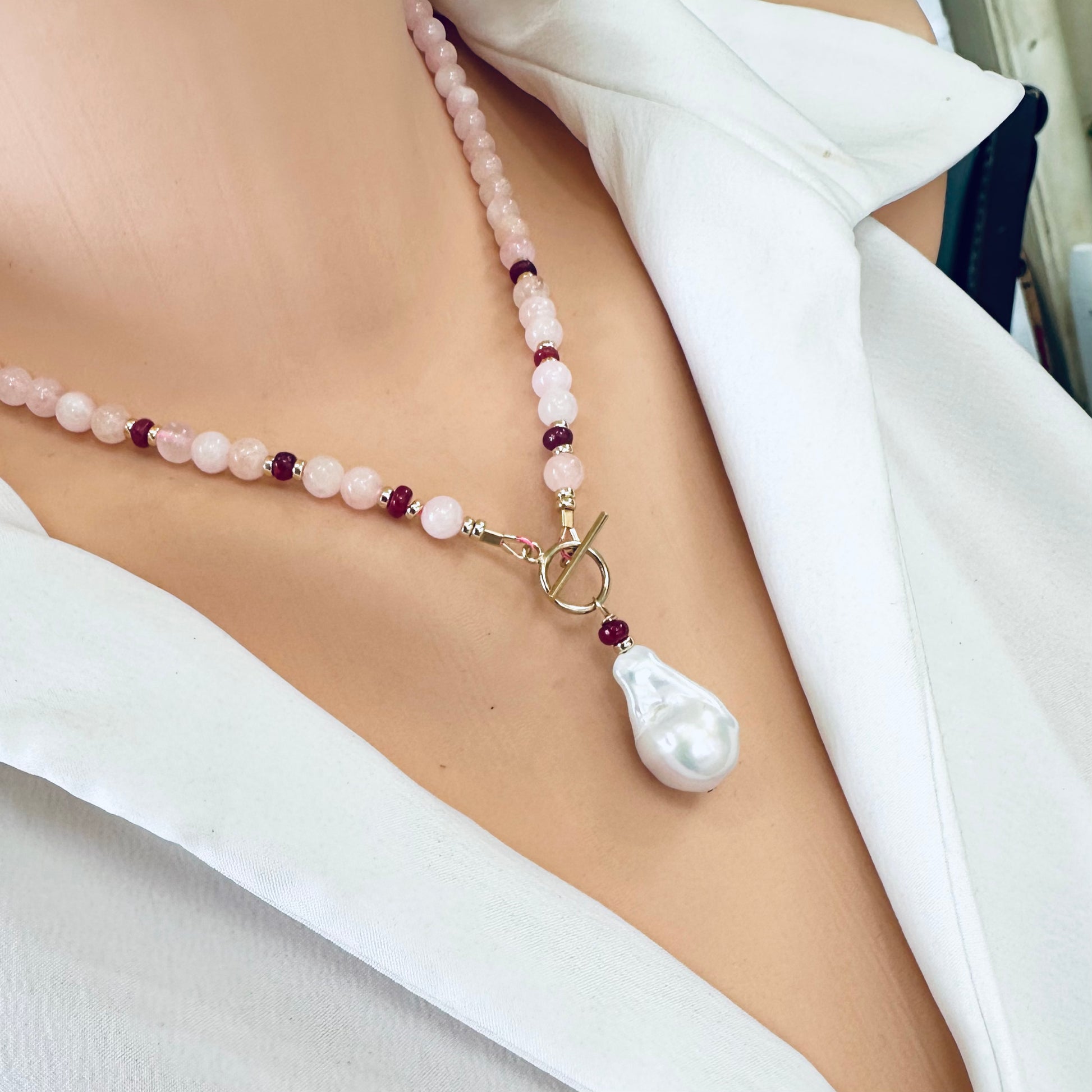 Side close-up of morganite necklace with ruby accents worn on mannequin