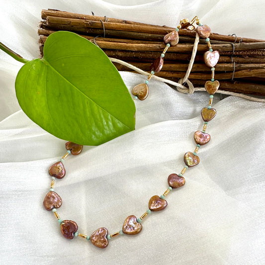 Bronze pearl choker with heart-shaped pearls displayed on white cloth