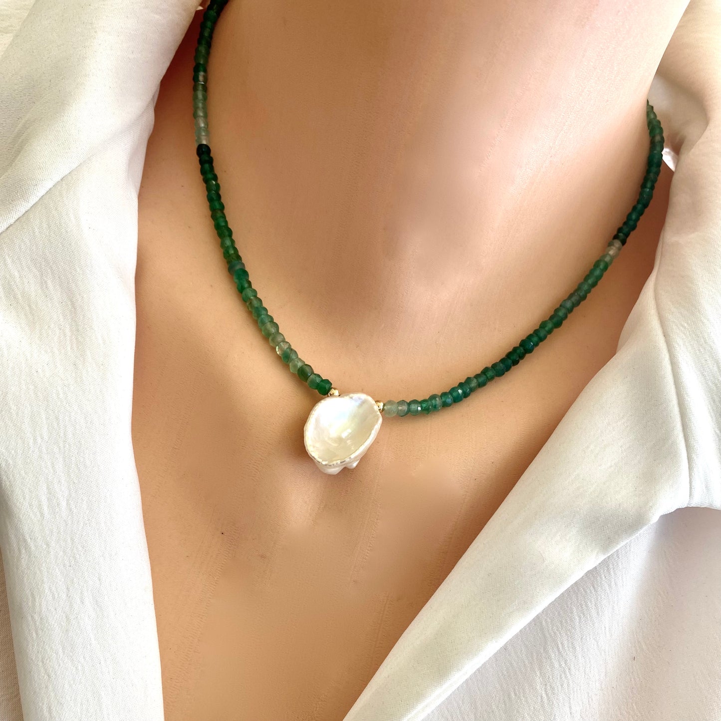 Green onyx keshi pearl necklace worn on model with shaded green beads and central pearl