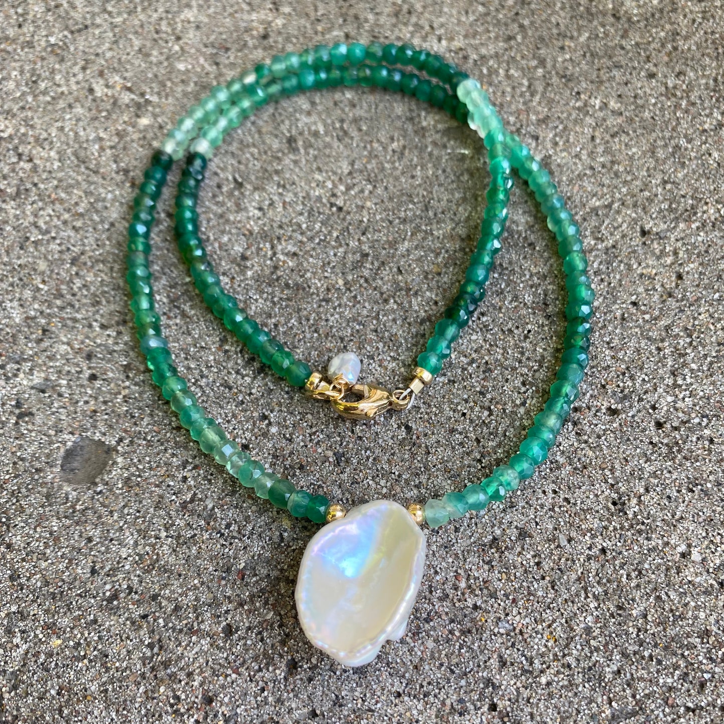 Green onyx keshi pearl necklace with gold filled details displayed flat