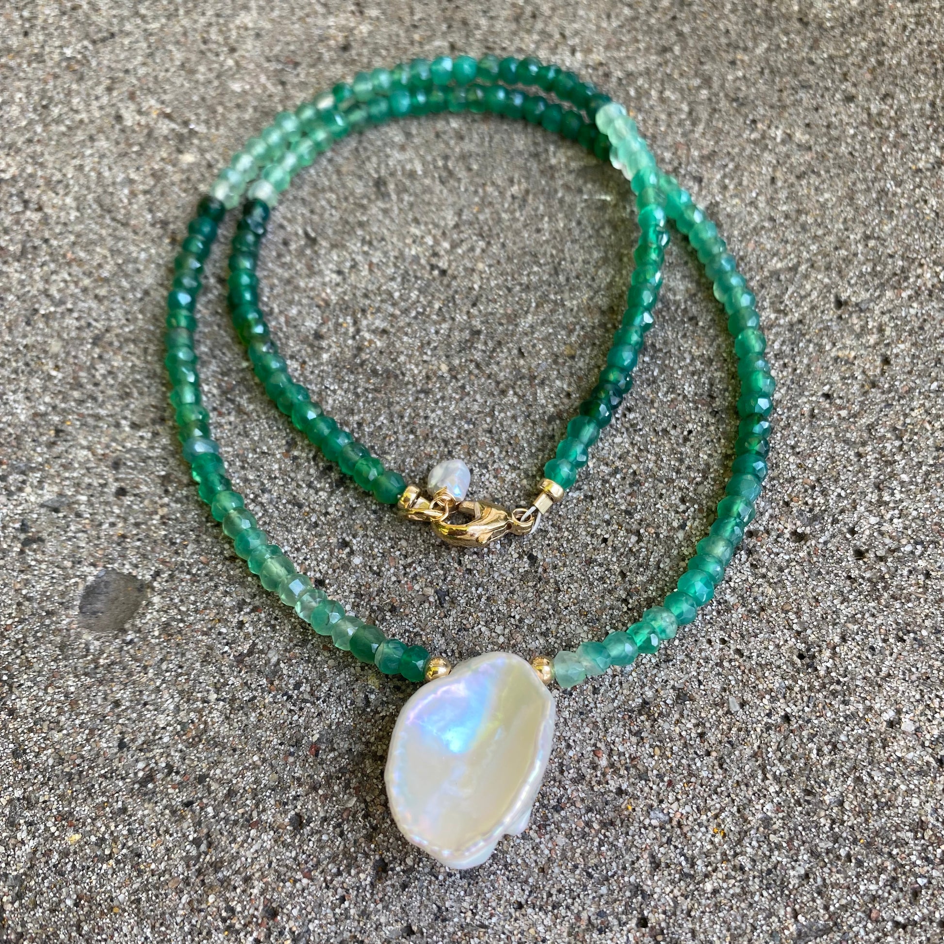 Green onyx keshi pearl necklace with gold filled details displayed flat