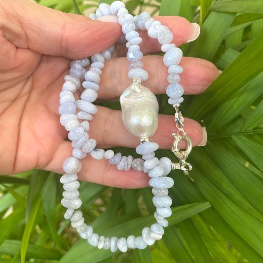Blue lace agate pearl necklace held in hand