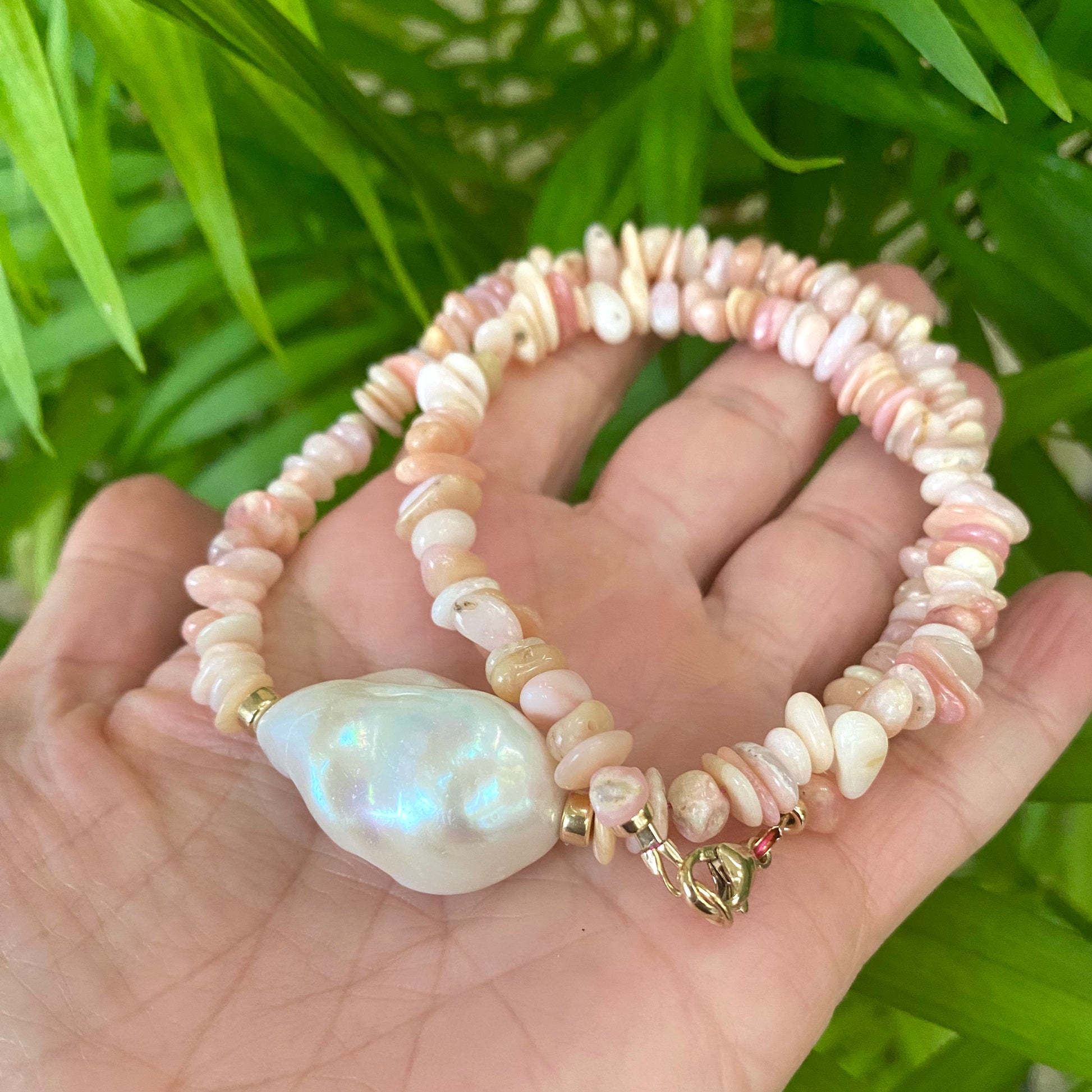 Pink opal pearl necklace held in hand