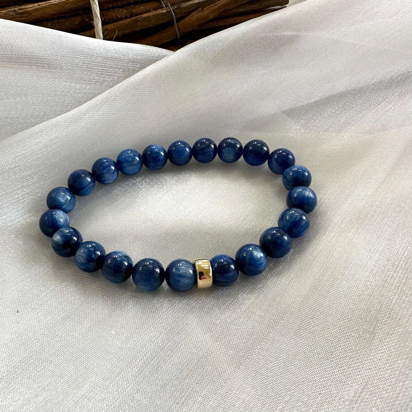 Close up of blue kyanite bracelet laid on white fabric