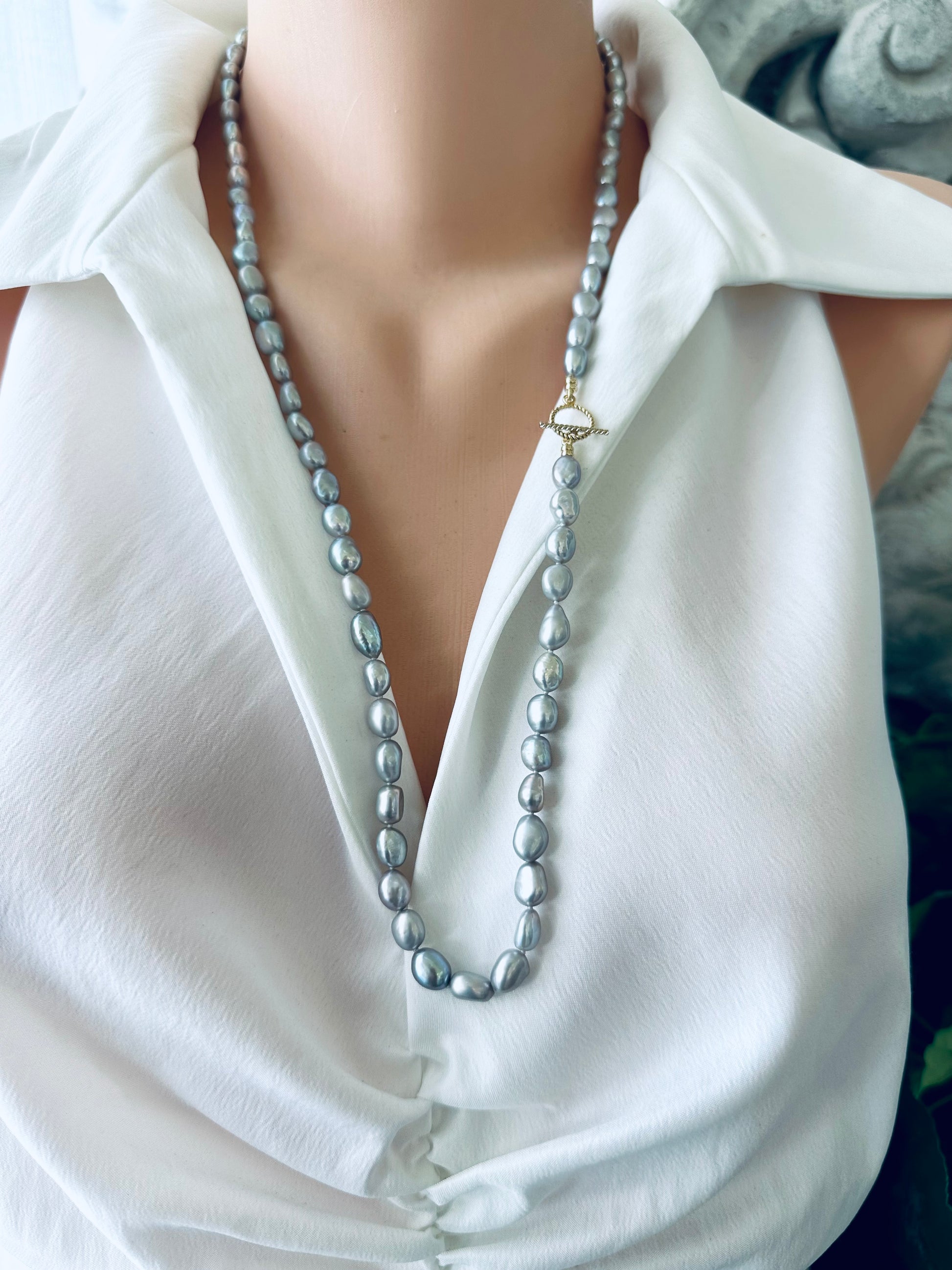 Grey nugget pearl necklace displayed on mannequin, frontal close-up