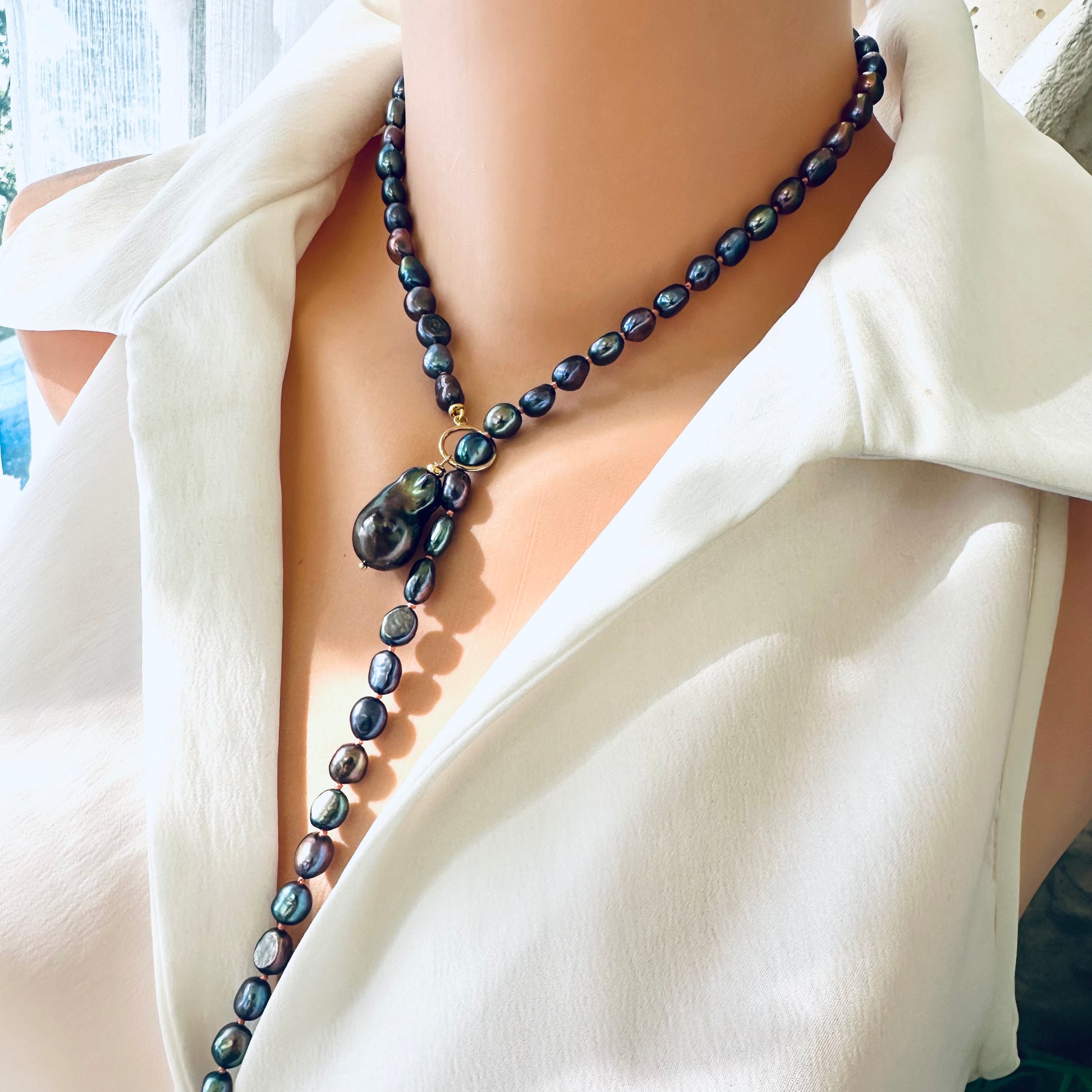 Peacock black pearl necklace with baroque pendant styled in a Y shape on mannequin