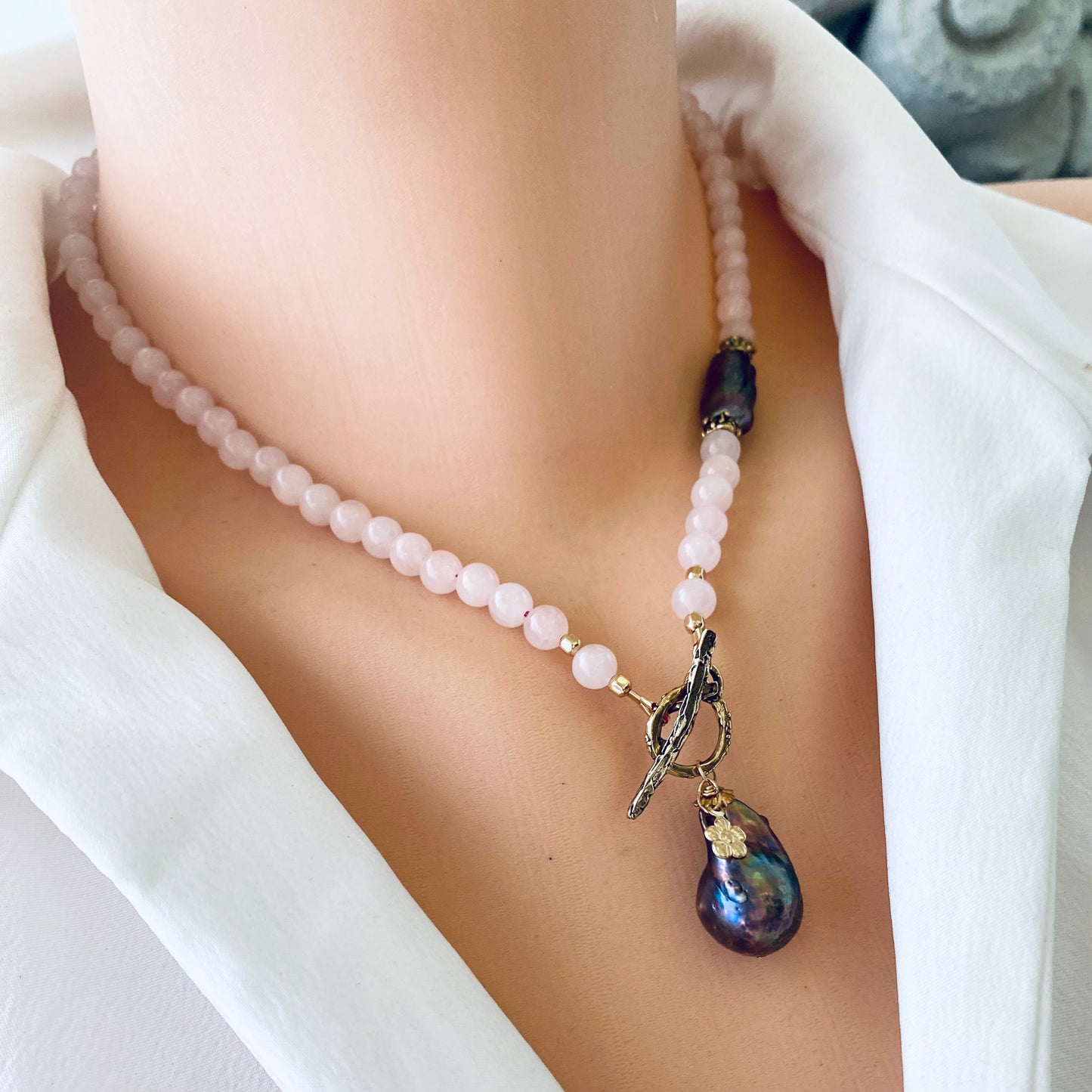 Rose quartz toggle necklace with black baroque pearl, showcasing blush-pink beads and a distinctive design.