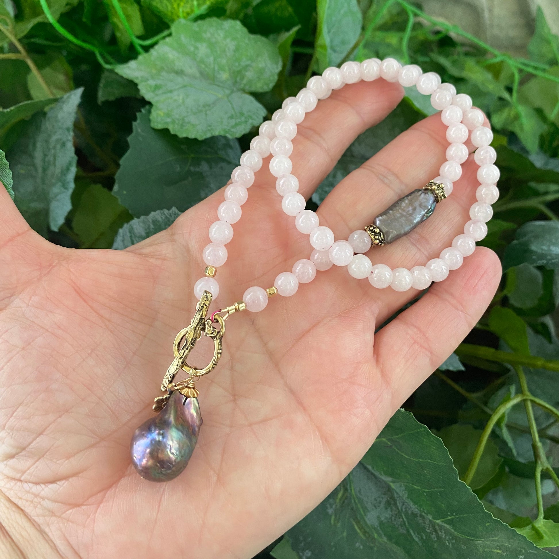 Rose quartz toggle necklace with black baroque pearl, showcasing delicate pink beads and a striking pearl drop.