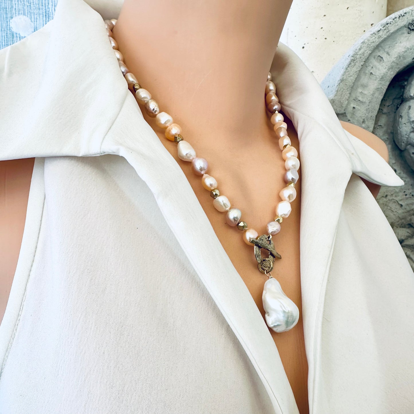 Pastel pearl necklace worn by mannequin side view highlighting gold bronze toggle clasp
