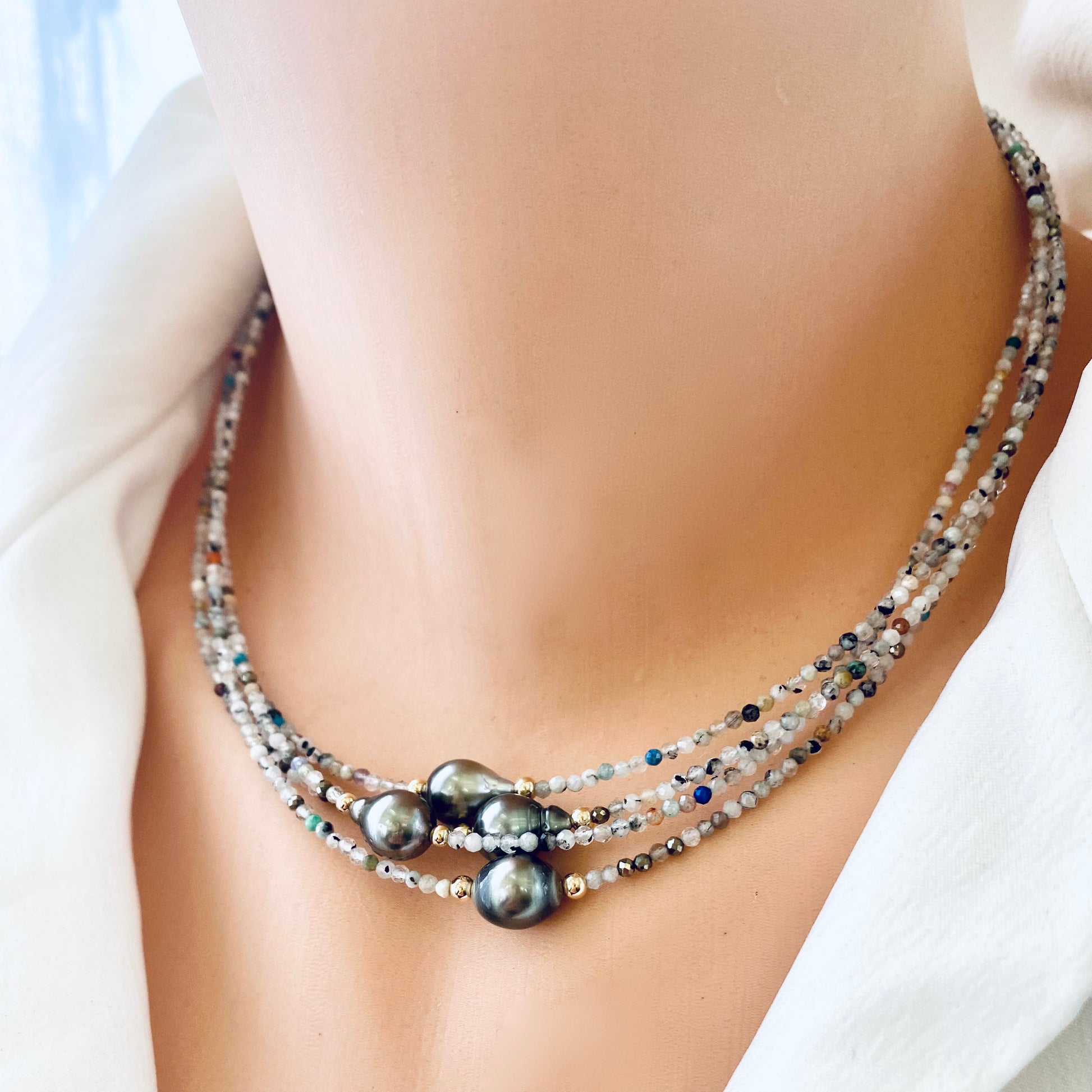 Multi stone pearl necklace layered on mannequin with three identical necklaces
