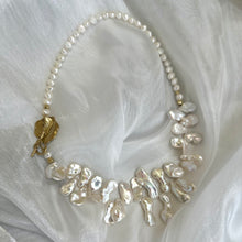 Load image into Gallery viewer, Stunning 19&quot; white Keshi pearls necklace, featuring a unique asymmetrical design that showcases both petal-shaped and nugget pearls with a beautiful golden vine leaf toggle clasp making this necklace not only easy to wear but a striking focal point.
