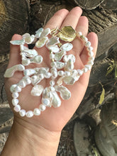 Load image into Gallery viewer, Stunning 19&quot; white Keshi pearls necklace, featuring a unique asymmetrical design that showcases both petal-shaped and nugget pearls with a beautiful golden vine leaf toggle clasp making this necklace not only easy to wear but a striking focal point.
