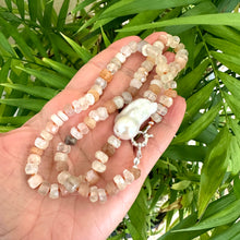 Load image into Gallery viewer, Hand-knotted necklace with mixed moonstone and a baroque pearl at the center, threaded with orange string, 20 inches long, featuring a sterling silver marine clasp.
