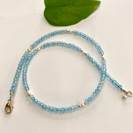 Blue topaz pearl choker necklace displayed on white cloth