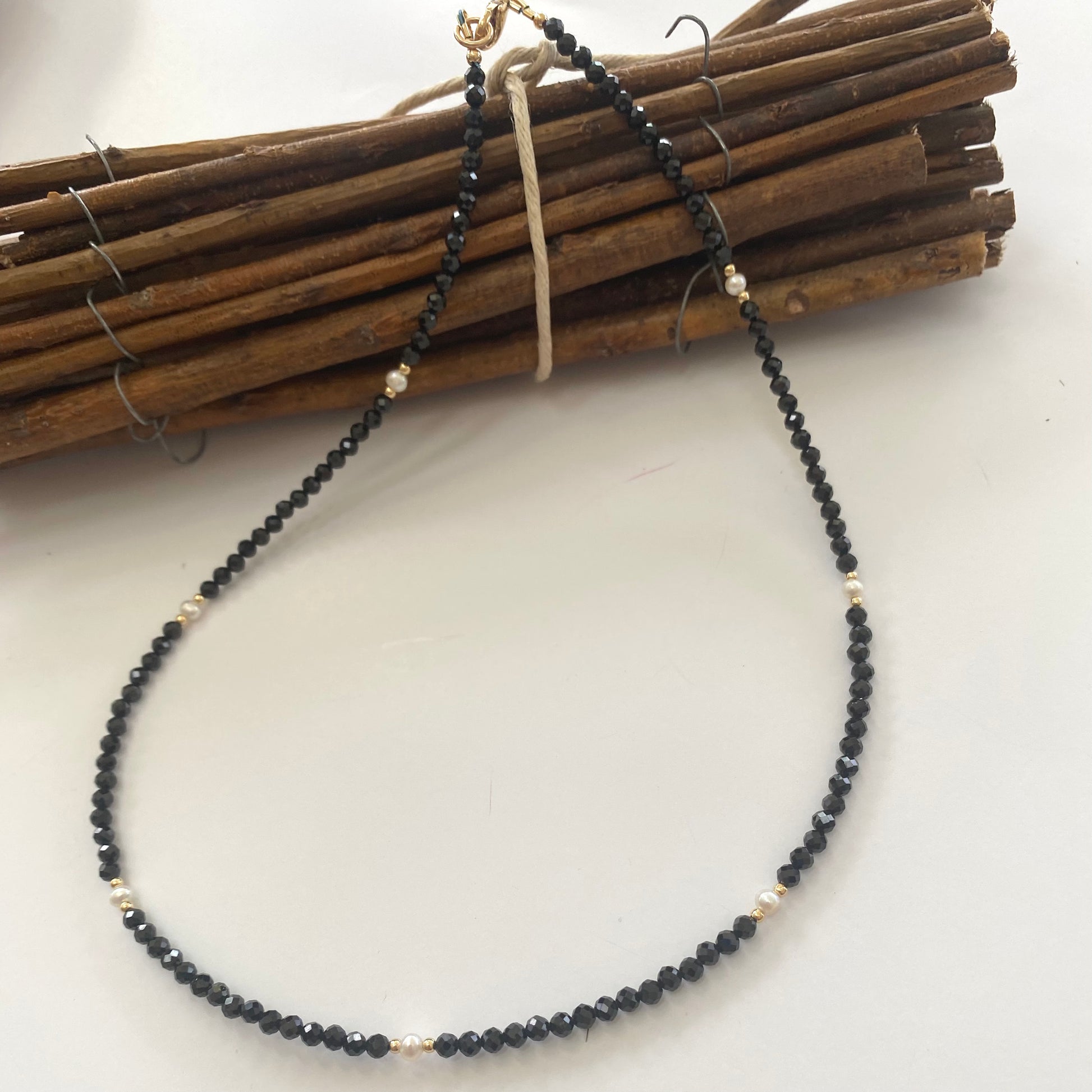 Black spinel pearl choker necklace displayed on white cloth
