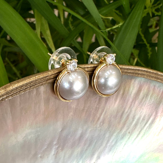 Silver grey pearl stud earrings with CZ – Gold Vermeil displayed on a natural shell background.