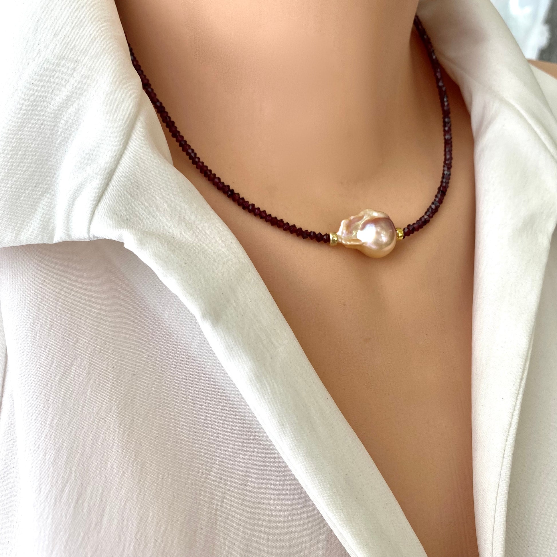 Red garnet baroque pearl necklace featuring golden pink pearl pendant, showcasing elegant design and rich color.