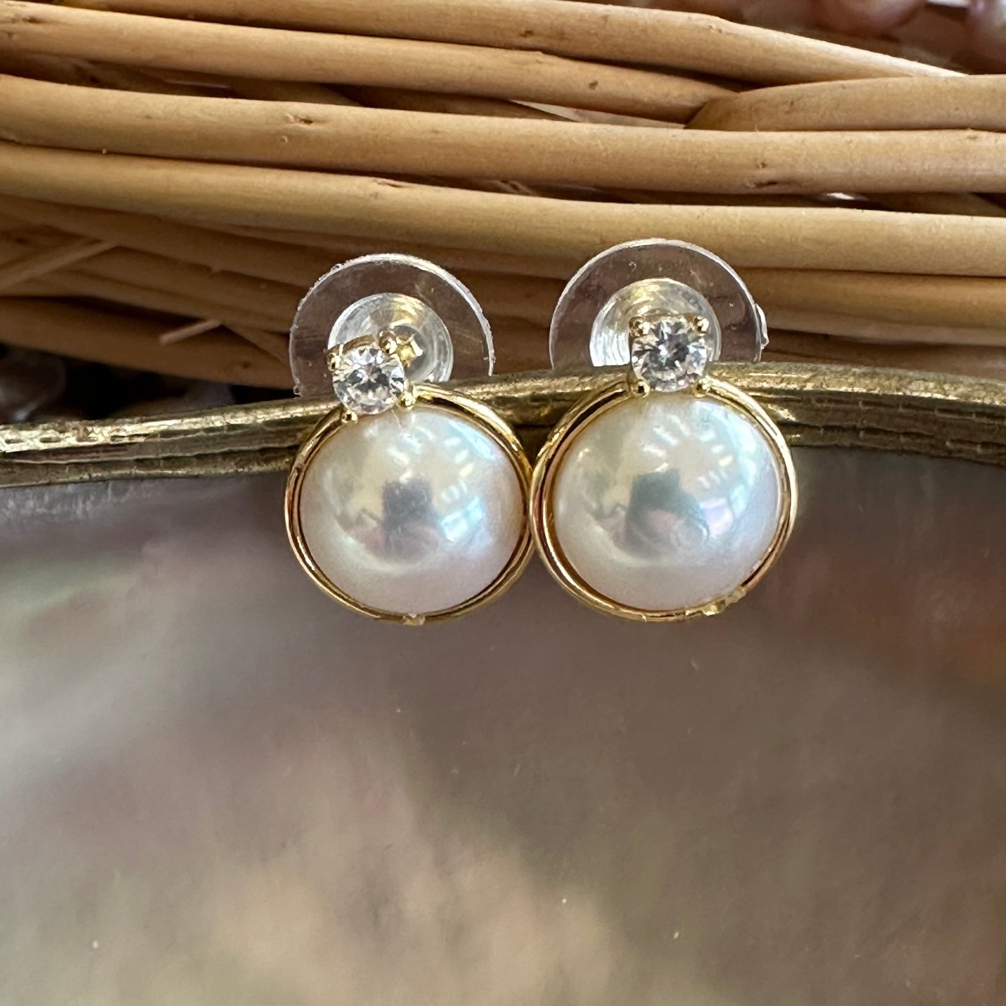 Mabe Edison pearl stud earrings in gold vermeil displayed on pearl and beige background