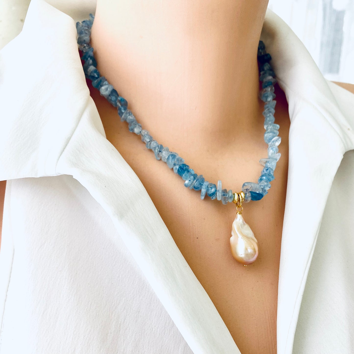 Aquamarine baroque pearl necklace featuring blue Aquamarine beads and a golden-pink Baroque pearl pendant.