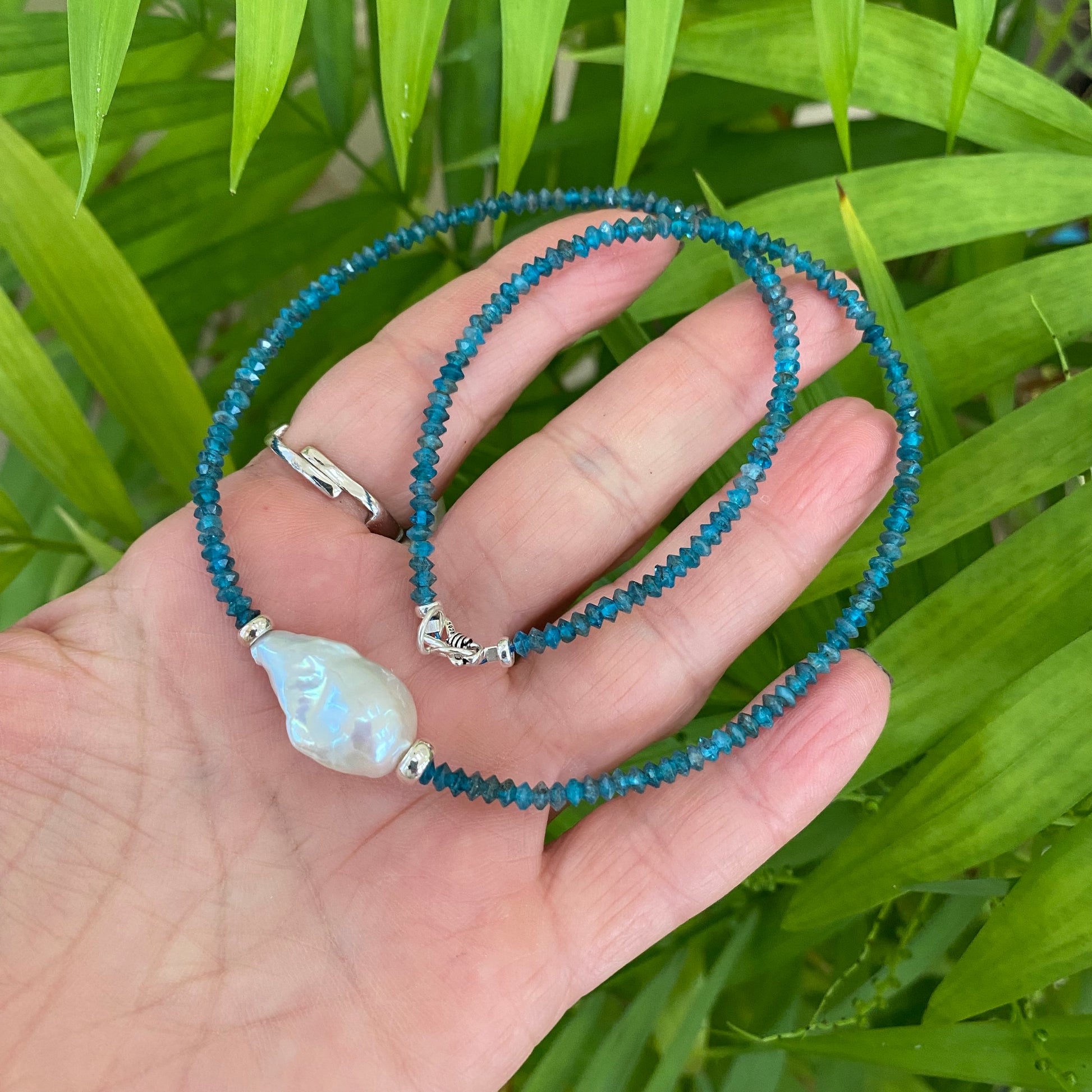 Dark blue apatite baroque pearl necklace featuring Apatite gemstones and a luminous Baroque pearl centerpiece.