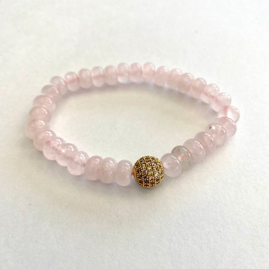 Rose quartz stretch bracelet with gold accent beads for a stylish and elegant accessory.