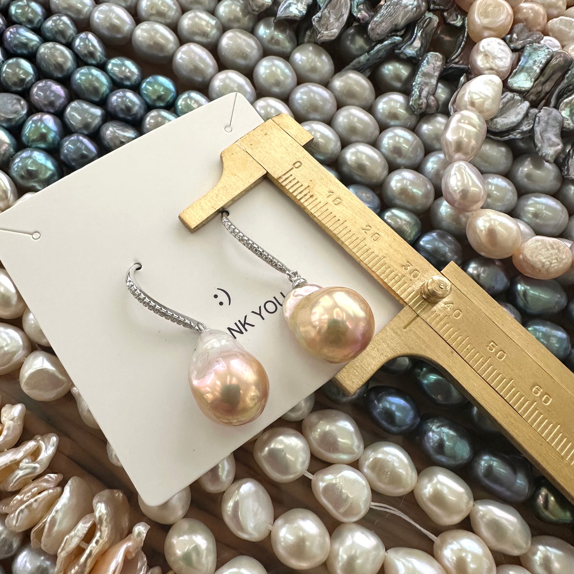 Golden pink baroque pearl dangle earrings measured for total drop length with ruler, designed and handmade in Canada.