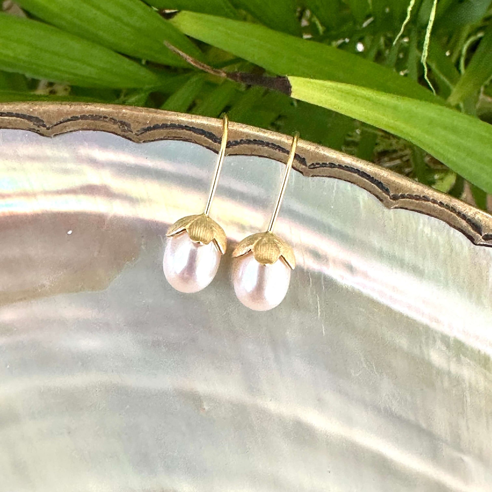 Rice Pearl Earrings – gold pair on pearl shell and green leaf backdrop