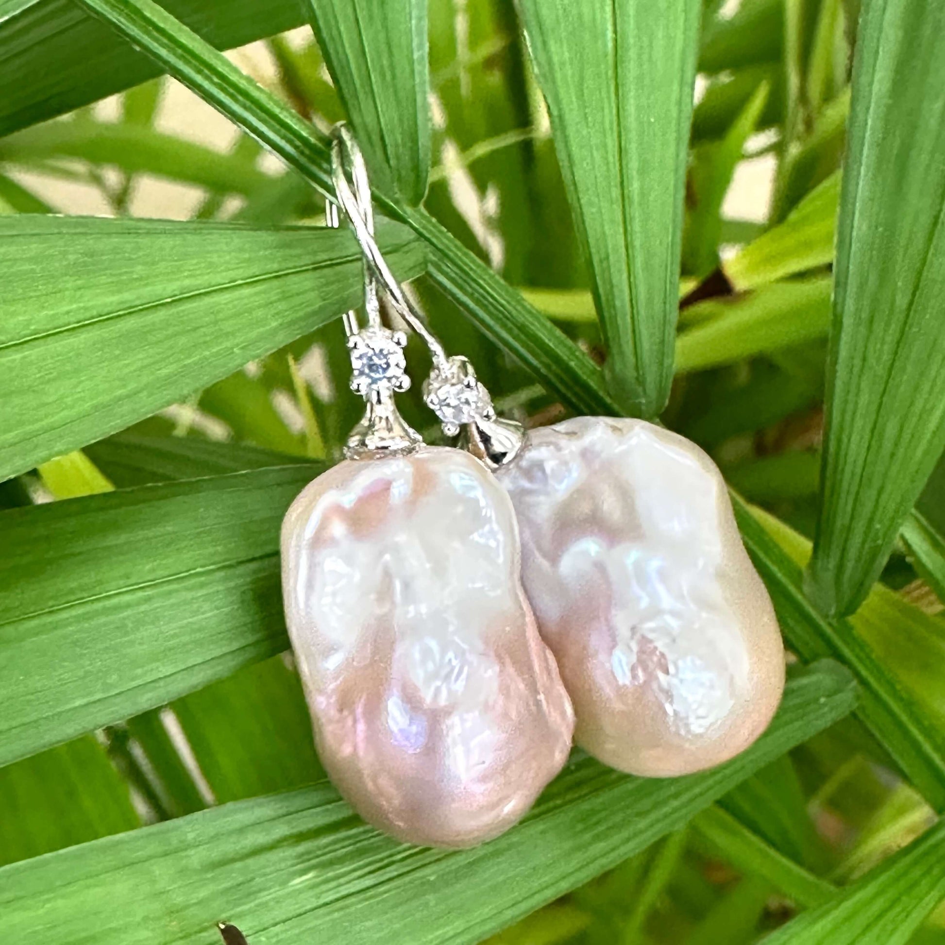 Lavender Baroque Pearl Earrings – close-up against green foliage backdrop