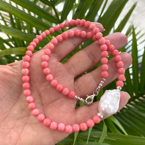 Pink coral and one large baroque pearl on the side of the necklace with sterling silver details, measuring 18.5 inches. This vibrant summer jewelry piece is perfect for beach outings and makes a thoughtful gift for her.